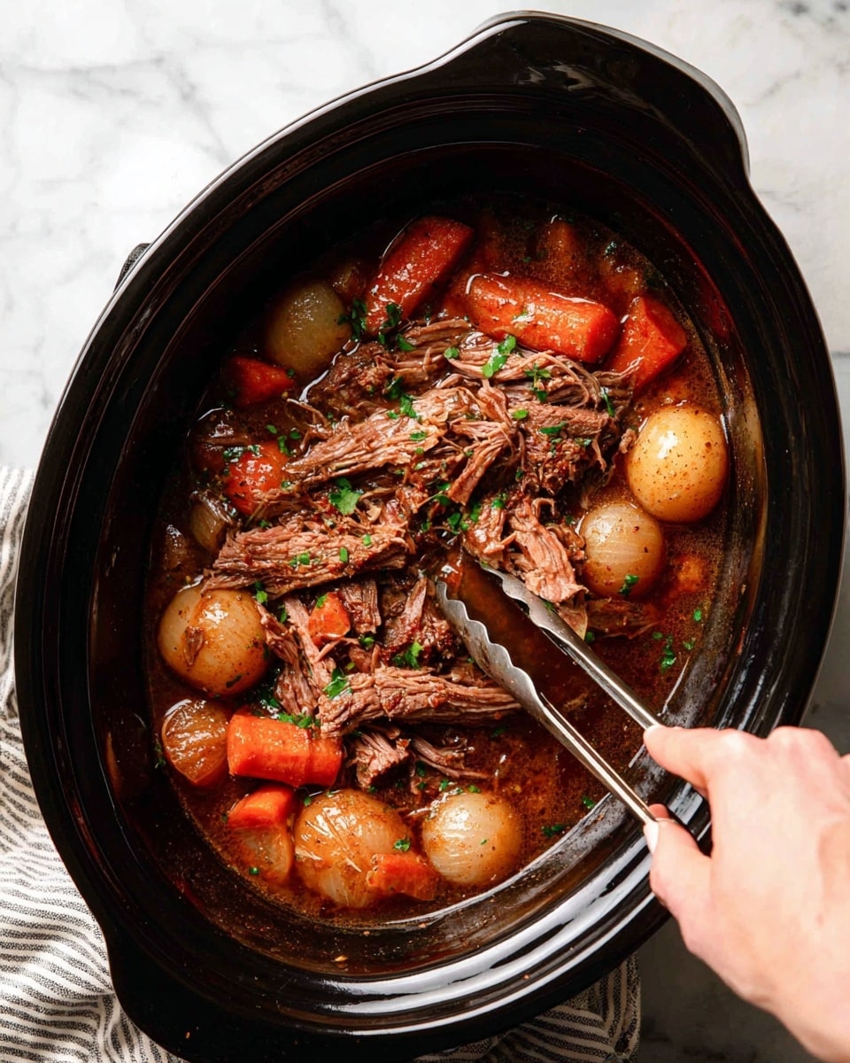 A close view of a black slow cooker filled with a stew showing layers of shredded brown meat mixed with orange carrots, whole small potatoes with brown skins, and chunks of translucent brown onions, all covered in a rich brown broth with green herb sprinkles on top. A woman's hand holds metal tongs, picking up some of the meat. The slow cooker rests on a white marbled surface next to a light beige textured cloth. photo taken with an iphone --ar 4:5 --v 7