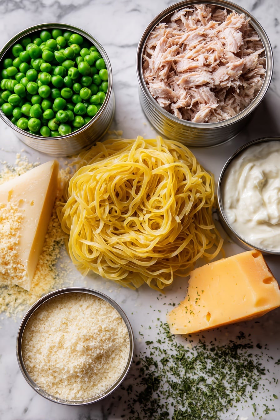 Flat lay of fresh yellow egg noodles coiled loosely, two shiny silver cans of tuna opened showing flaky light pink tuna, a small pile of bright green frozen peas glistening with frost, a wedge of sharp orange cheddar cheese with a slightly crumbly texture, a mound of creamy sour cream with a smooth surface, a handful of golden brown panko breadcrumbs with a rough texture, a small heap of pale beige grated parmesan cheese, and scattered dried parsley flakes in vibrant green, all arranged artfully to highlight their natural colors and textures, placed on white marbled surface, photo taken with an iphone --ar 2:3 --v 7 - Classic Tuna Noodle Casserole, Tuna Noodle Casserole with Parmesan Breadcrumb Topping, Easy Tuna Casserole Recipe, Creamy Tuna Casserole, Comfort Food Tuna Bake