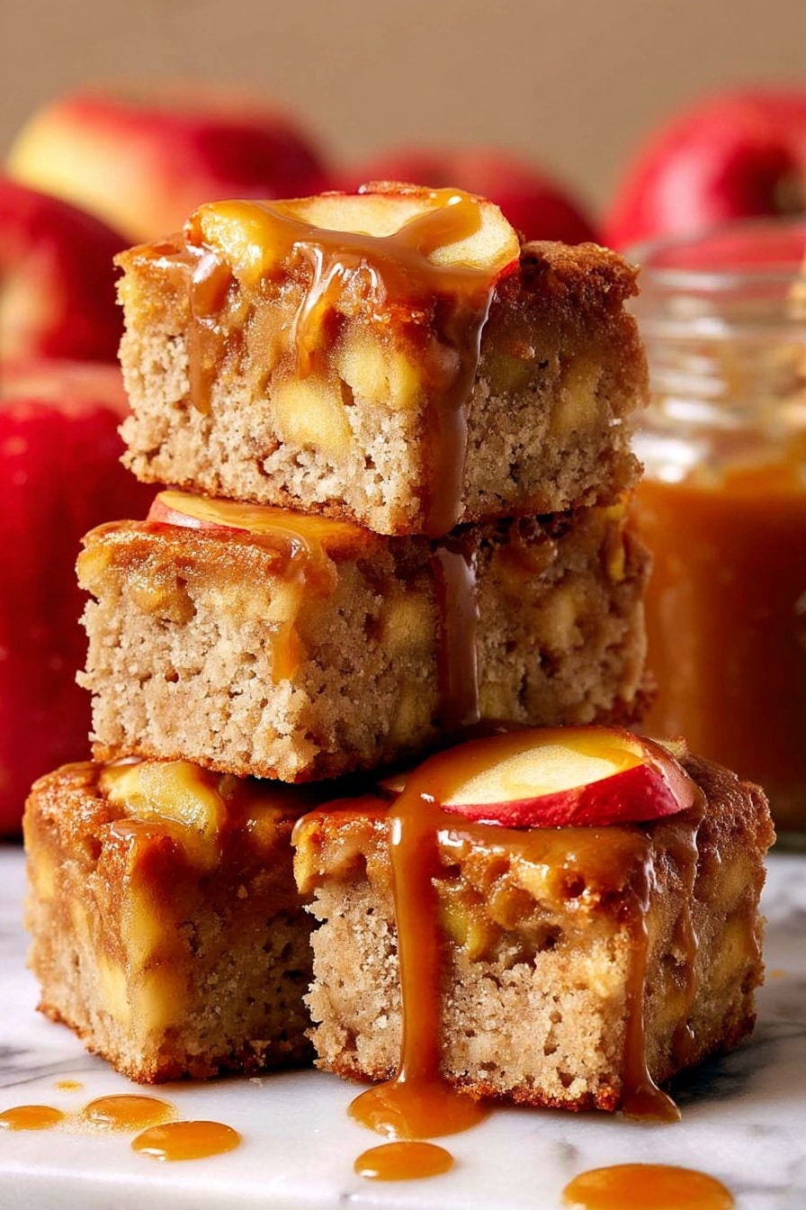 The image shows four thick square pieces of apple cake stacked on each other on a white marbled surface. Each piece has a light brown, porous texture with visible chunks of apple inside and apple slices on top. The top layer is covered in a shiny, caramel brown sauce that drips down the sides of the cake pieces. In the background, there are red apples and a glass jar filled with caramel sauce, slightly blurred. The lighting highlights the moist texture of the cake and the glossy caramel sauce photo taken with an iphone --ar 2:3 --v 7 - Caramel Apple Cake,Apple Cake with Caramel,Autumn Dessert Recipes,Easy Apple Cake,Fall Baking Ideas