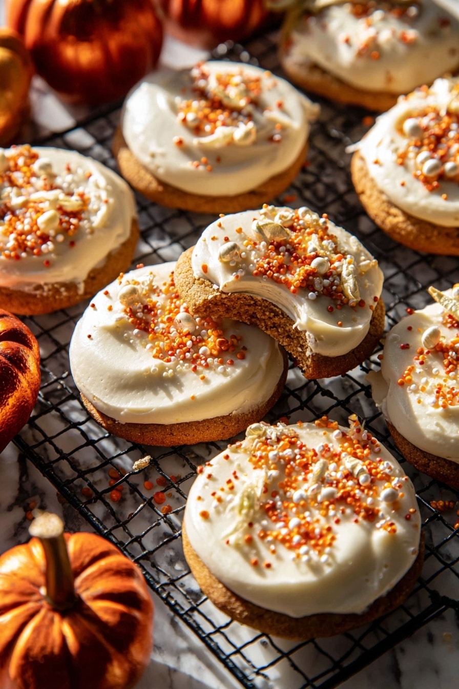 The image shows a group of round cookies, each with one thick, creamy white frosting layer on top. The frosting is smooth and spread evenly, decorated with small orange, white, and gold sprinkles scattered on the surface. One cookie is lifted slightly, showing the soft brown cookie base beneath the frosting. The cookies rest on a black wire cooling rack placed on a white marbled surface. Around the cookies, there are a few small, shiny dark orange mini pumpkins adding a warm autumn feel. Bright sunlight shines on the scene, creating strong shadows and highlighting the textures. Photo taken with an iphone --ar 2:3 --v 7 - Frosted Soft Pumpkin Sugar Cookies, pumpkin spice cookies, fall sugar cookies, pumpkin butter cookies, soft pumpkin cookies with frosting