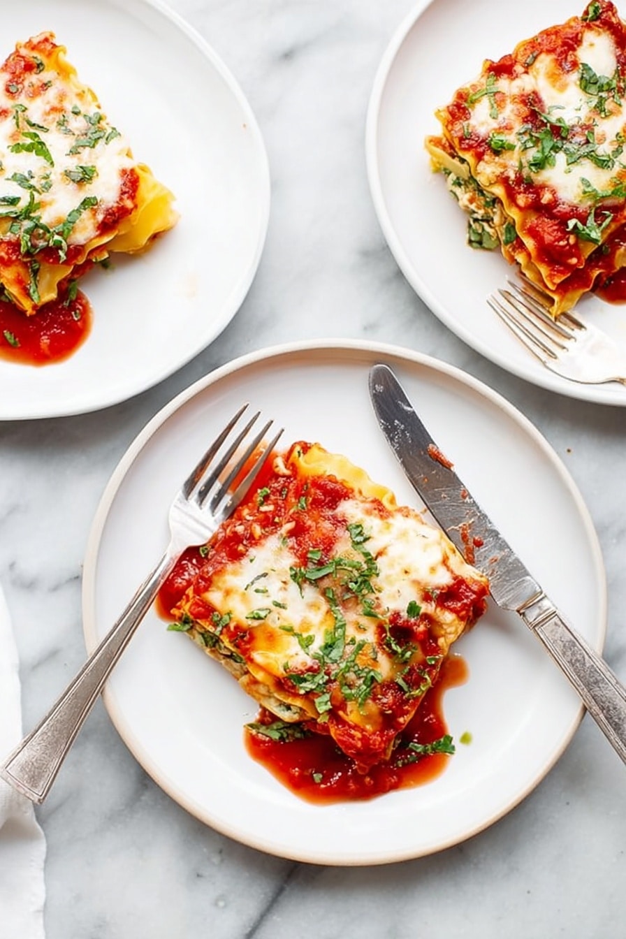 There are three white plates on a white marbled surface, each with a square piece of lasagna. Each lasagna piece has visible layers: a red tomato sauce at the bottom, a yellow pasta sheet, white cheese melted on top with some browned spots, and green herbs sprinkled over all. One plate in the middle has a fork and a knife resting on the edges, the knife laying diagonally across the plate. The tomato sauce slightly spreads around each lasagna piece, adding a bright red contrast to the white plates and light background. Photo taken with an iphone --ar 2:3 --v 7 - Spinach Lasagna Roll-Ups, healthy lasagna roll-ups, easy spinach lasagna, baked spinach roll-ups, creamy ricotta spinach casserole