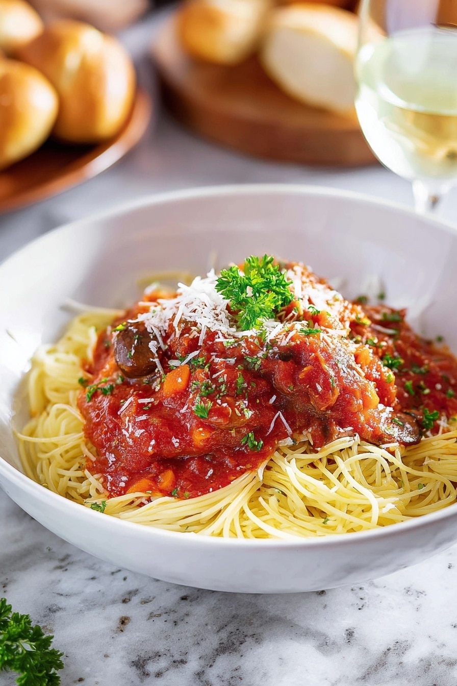A white bowl filled with a bed of yellow spaghetti noodles forms the bottom layer, topped with red tomato sauce mixed with dark brown mushroom pieces and a piece of cooked white meat covered in sauce at the center. White shredded cheese is sprinkled lightly over the sauce and meat, and a small green parsley sprig sits on top for garnish. A golden brown breadstick lies diagonally on the left edge of the bowl. The bowl is placed on a white marbled surface with a metal fork resting inside the bowl on the right side, partially under the sauce. Photo taken with an iphone --ar 2:3 --v 7 - Slow Cooker Chicken Cacciatore, Italian chicken dinner, easy slow cooker chicken recipe, hearty Italian chicken stew, tender chicken with tomato sauce
