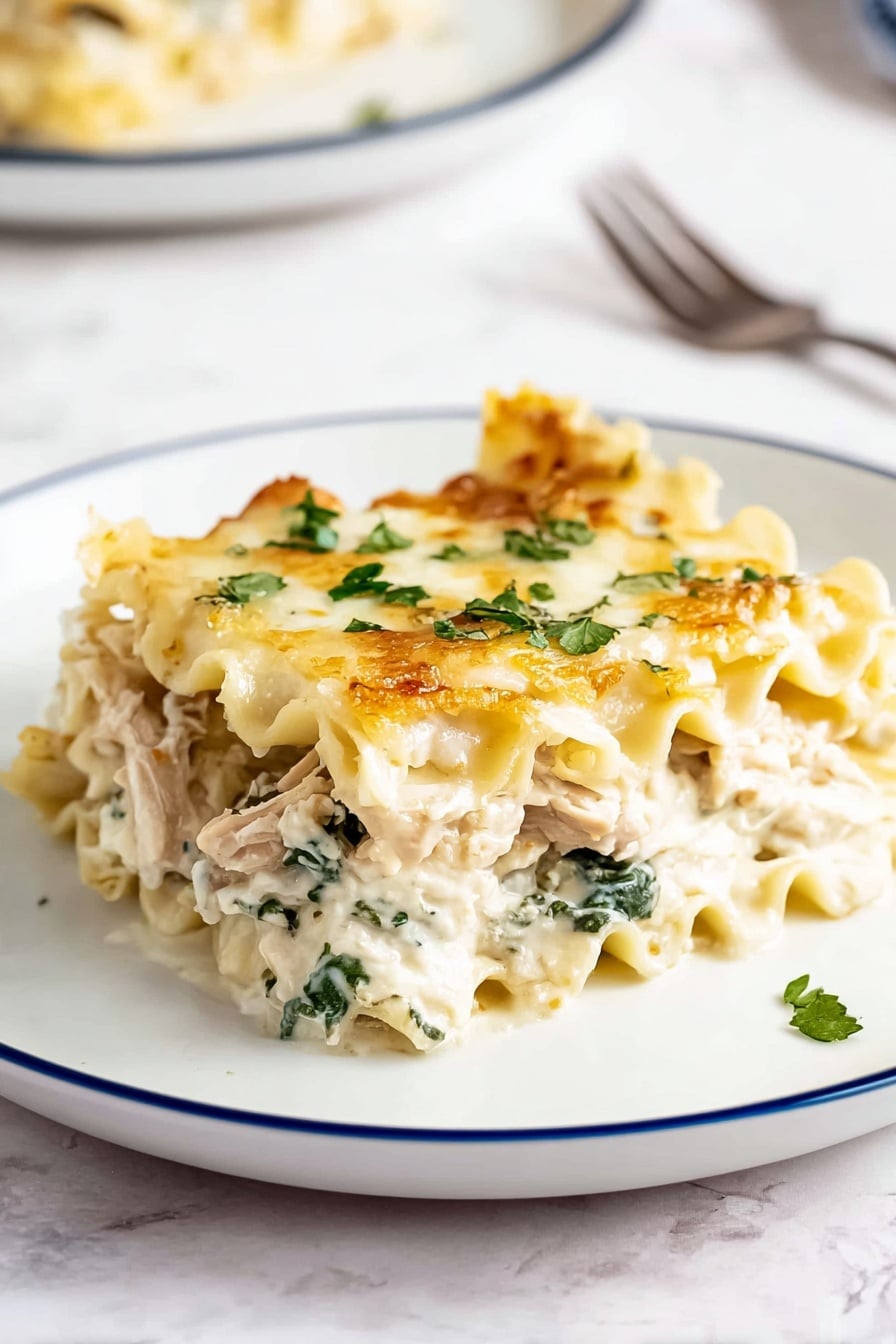 A single piece of lasagna is placed on a white plate with a thin blue rim, showing about four layers. The top layer is light golden with melted cheese and small green parsley flakes scattered on it. Below that is a creamy white sauce mixed with green spinach leaves and chunks of light brown cooked chicken. The pasta layers are soft and wavy, pale yellow in color, separating the cheesy and vegetable layers. The plate is on a white marbled surface with a blurred second plate and a fork in the background. Photo taken with an iphone --ar 2:3 --v 7 - Creamy Chicken Boursin Lasagna, Boursin cheese lasagna, creamy chicken pasta bake, easy chicken lasagna, comforting chicken casserole