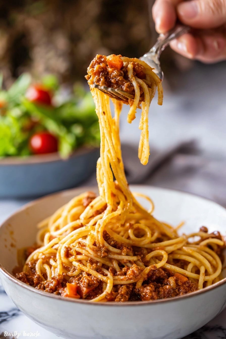 A close-up image shows a woman's hand holding a fork and spoon lifting a twirl of spaghetti from a white bowl filled with spaghetti bolognese. The spaghetti's long, thin yellow noodles are covered in a chunky, reddish-brown tomato sauce with visible bits of carrots and minced meat. The sauce coats the bottom layer of the bowl, creating a textured base under the lifted pasta. In the background, a blurred bowl of green salad with cherry tomatoes sits on a white marbled surface. The image focuses on the pasta being lifted, highlighting the sauce's texture and pasta's smooth strands. Photo taken with an iphone --ar 2:3 --v 7 - Slow Cooker Bolognese Sauce, easy slow cooker pasta sauce, hearty Italian meat sauce, make-ahead Bolognese, flavorful slow cooker recipes