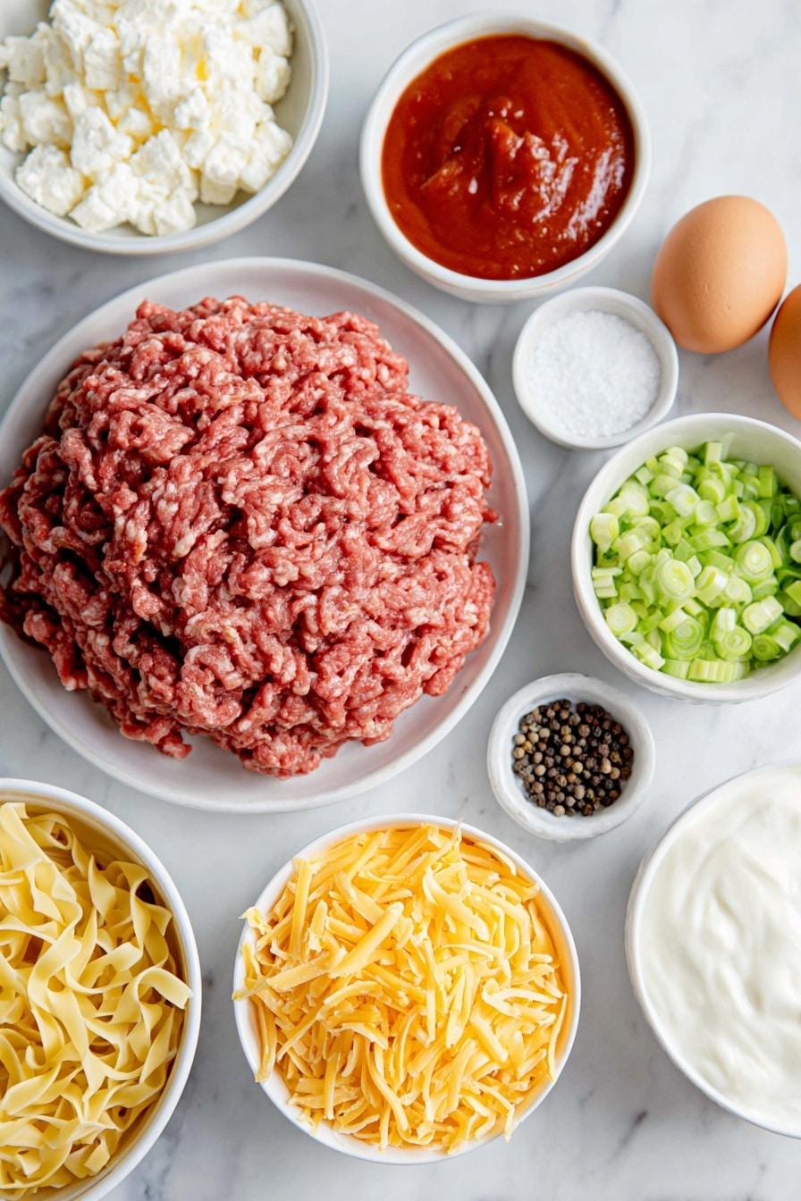 Flat lay of fresh raw ground chuck shaped in a loose mound, a small white ceramic bowl of smooth red tomato sauce, a small white ceramic bowl of thick white sour cream, a small white ceramic bowl filled with small curd cottage cheese, a neat pile of uncooked golden egg noodles, a handful of vibrant green sliced green onions arranged in a small white ceramic bowl, a small white ceramic bowl heaped with shredded sharp cheddar cheese, two whole brown eggs with clean shells, a small white ceramic bowl of coarse black peppercorns, a small white ceramic bowl of white salt crystals, all placed with perfect symmetry on a clean white marble surface, soft natural light, photo taken with an iPhone, professional food photography style, fresh ingredients, white ceramic bowls, no bottles, no duplicates, no utensils, no packaging --ar 2:3 --v 7 --p m7354615311229779997 - Sour Cream Noodle Bake, creamy casserole recipes, quick family dinners, baked noodle dishes, comfort food recipes