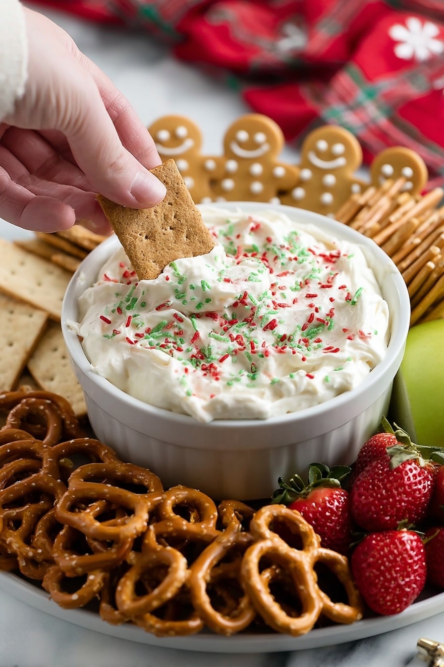 A close-up image of a white bowl filled with thick white cream cheese dip with red, green, and white sprinkles on top. A woman's hand is dipping a rectangular graham cracker into the bowl. Surrounding the bowl are clusters of gingerbread man-shaped cookies standing upright at the back, golden pretzels at the front, and more rectangular graham crackers stacked on the left side. Fresh strawberries and a green apple slice are positioned on the right. The entire plate is placed on a white marbled surface with a red and white cloth blurred in the background. Photo taken with an iphone --ar 2:3 --v 7 - Christmas Cookie Dough Dip, festive holiday dip, no-bake Christmas dessert, easy Christmas treat, Christmas party snack