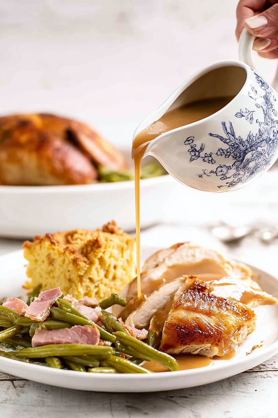 A white plate sits on a white marbled surface, holding four food layers. At the front, there is a large piece of sliced roasted chicken with a golden-brown crispy skin. Brown gravy is poured over the chicken from a white gravy boat decorated with a blue traditional pattern, held by a woman's hand. To the left of the chicken is a helping of green beans mixed with pieces of pink ham. Behind the green beans is a thick, golden piece of cornbread with a crumbly texture. In the background, part of a roasted chicken with a brown crispy skin is visible on another white plate. Photo taken with an iphone --ar 2:3 --v 7 - Oven Roasted Turkey with Gravy, Thanksgiving turkey recipe, Juicy roasted turkey, Easy turkey with gravy, Holiday centerpiece recipes