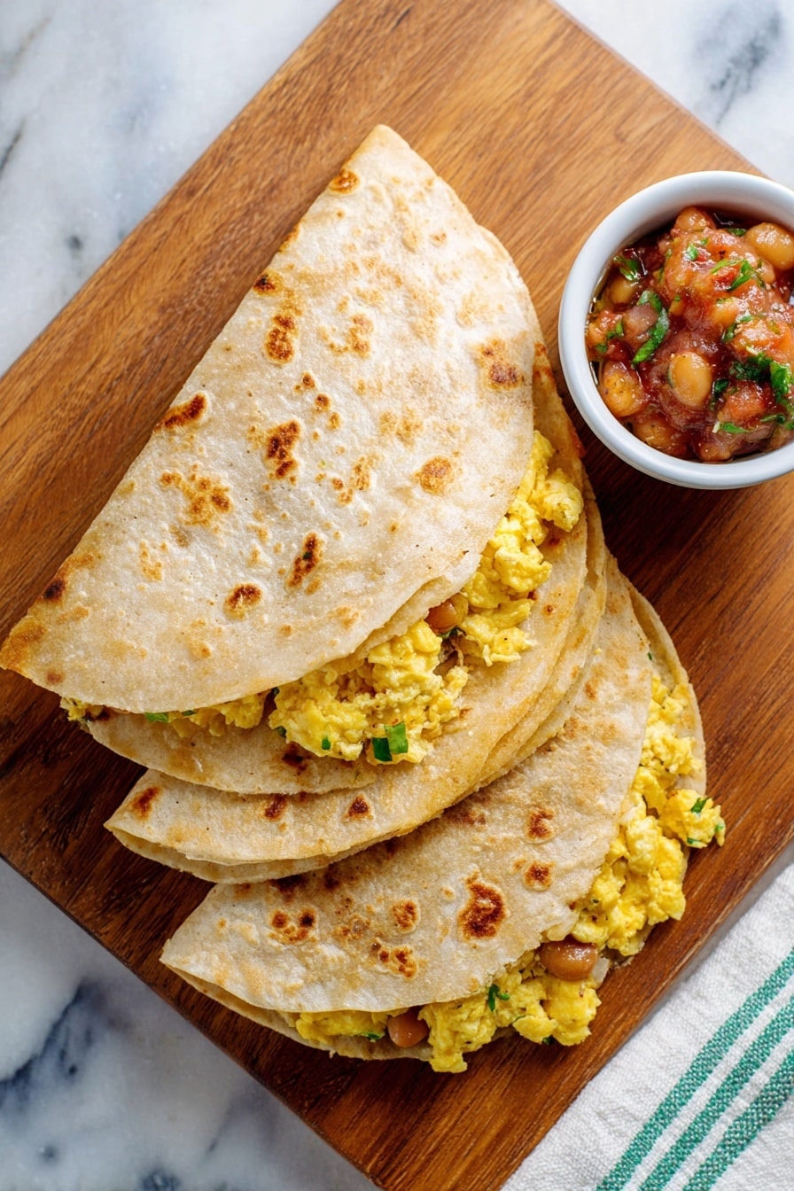 Two folded tortillas, each with two layers visible: the outer layer is a light tan with toasted brown spots, and inside there is a bright yellow scrambled egg mixture with gooey melted cheese and brown beans mixed with bits of green herbs, all peeking out slightly from under the tortillas. Behind the tortillas is a white bowl with blue patterns filled with chunky salsa showing red tomato, green herbs, and other diced vegetables. Everything is on a wooden board placed on a white marbled surface. Photo taken with an iphone --ar 2:3 --v 7 - Easy Breakfast Quesadilla with Eggs and Beans, breakfast quesadilla recipe, quick morning breakfast, protein-packed breakfast ideas, cheesy breakfast quesadilla