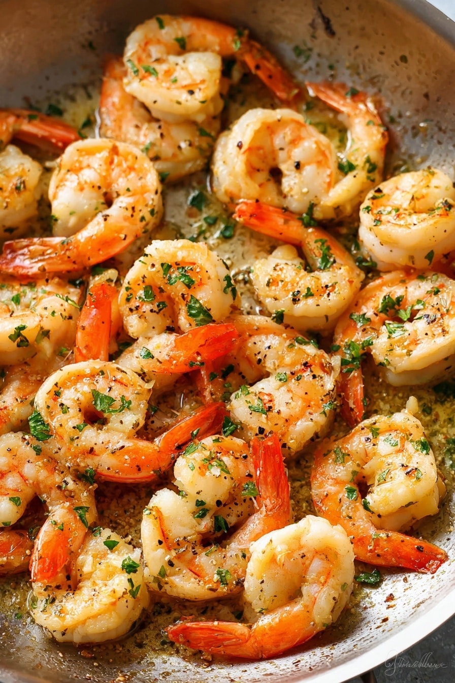 A close-up view of a pile of cooked shrimp in warm light, the shrimp are curled with bright orange tails and creamy white bodies, each piece sprinkled with small green parsley leaves, the shrimp sit in a glossy light yellow butter sauce with tiny bits of seasoning visible, a wooden spoon partially lifts some shrimp from the mix, the scene is set against a white marbled textured surface, showing the moist texture and fresh herbs clearly, photo taken with an iphone --ar 2:3 --v 7 - Garlic Butter Shrimp Scampi, shrimp scampi pasta, easy seafood recipes, quick shrimp recipes, elegant shrimp dinners