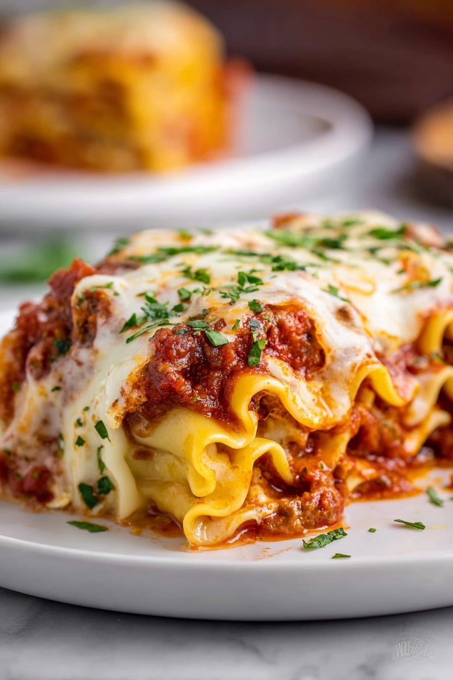 The image shows a close-up of a rolled lasagna piece on a white plate, placed over a white marbled surface. The lasagna has many wavy layers of soft, yellow pasta filled with a thick red meat sauce and melted cheese. The top is covered with a layer of creamy white melted cheese that is slightly browned in spots, sprinkled with bright green chopped herbs. The sauce peeks through the edges of the pasta rolls, adding a rich red color to the dish. In the blurred background, part of another portion is visible on a similar white plate. Photo taken with an iphone --ar 2:3 --v 7 - Cheesy Beef Lasagna Roll-Ups, beef lasagna roll-ups, cheesy lasagna roll-ups, easy lasagna roll-ups, baked beef lasagna roll-ups