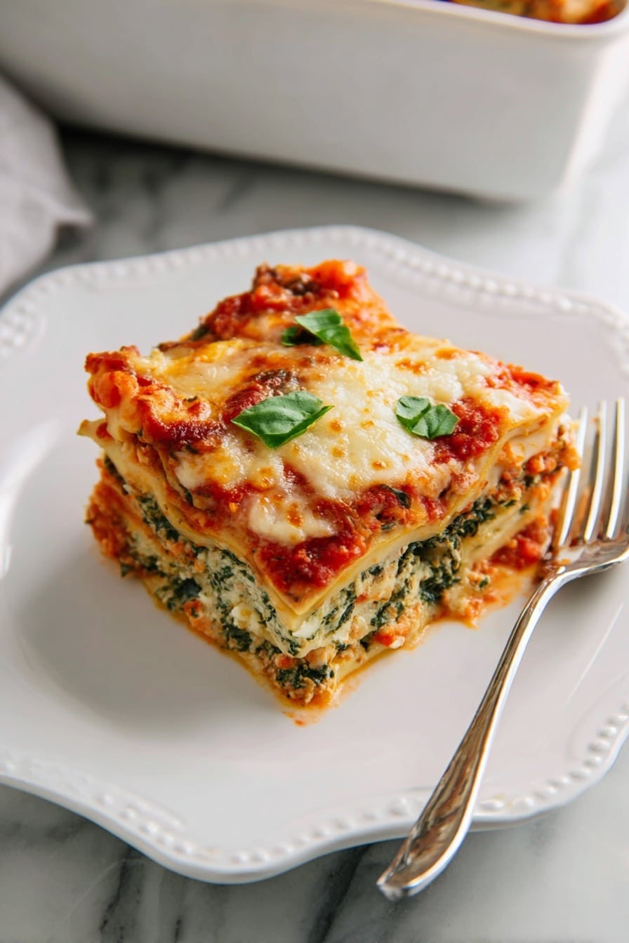 A white square baking dish holds a fresh lasagna with visible layers of rich red tomato sauce mixed with meat and bits of yellow pasta beneath a thick, bubbly layer of melted cheese that is golden brown in spots. Bright green chopped basil leaves are sprinkled over the top, adding fresh color and shine. The dish rests on a soft dark blue cloth on a white marbled surface, and extra basil leaves are placed beside it, creating a clean and inviting look. Photo taken with an iphone --ar 2:3 --v 7 - Spinach Artichoke Lasagna, vegetarian lasagna with spinach and artichokes, creamy vegetable lasagna, healthy lasagna recipes, easy homemade lasagna