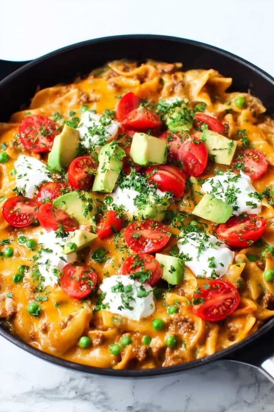 A black cast iron pan filled with a layered baked pasta dish topped with melted bright orange cheese, scattered green chopped herbs, and chopped green onions. On top are halved red cherry tomatoes, chunks of light green avocado, and dollops of white sour cream. A wooden spoon is scooping some of the pasta from the right side, showing short tube-shaped pasta mixed with meat and sauce underneath the cheese layer. The whole scene is set on a white marbled surface. photo taken with an iphone --ar 2:3 --v 7 - Cheesy Enchilada Pasta Skillet, enchilada pasta, cheesy skillet dinner, quick enchilada pasta, one-pot cheesy pasta