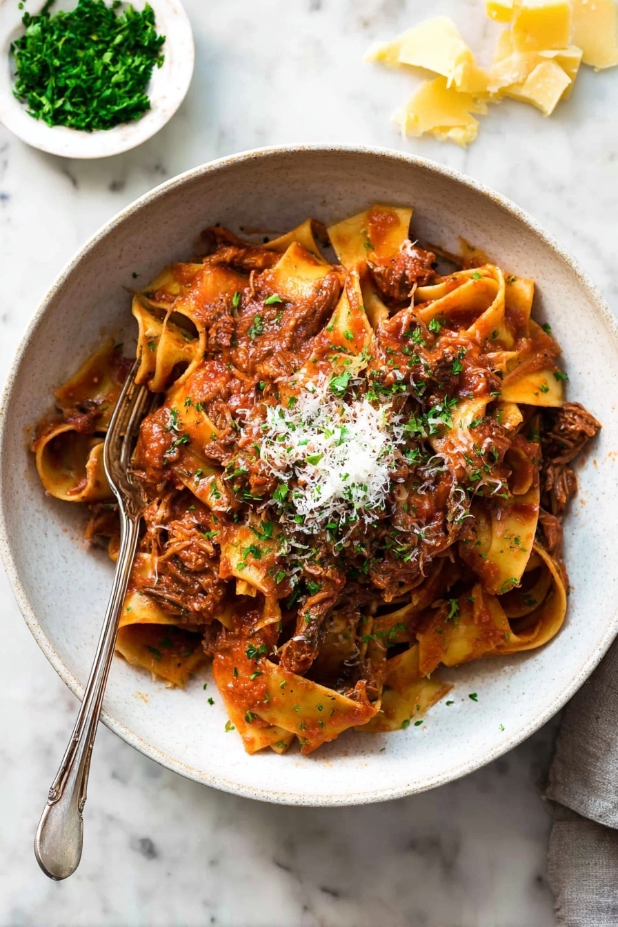 A bowl filled with wide, soft pasta noodles layered with shredded brown meat mixed in a thick red tomato sauce. The pasta sits in a white bowl, topped with a small pile of grated light cheese and finely chopped green herbs. A fork is placed inside the bowl, resting on the pasta. The background shows a white marbled surface with a small white dish holding chopped green herbs and pieces of yellow cheese scattered nearby. Photo taken with an iphone --ar 2:3 --v 7 - Slow Cooked Beef Ragu with Pasta, Italian beef ragu, hearty pasta dish, slow cooker beef recipes, comfort food pasta