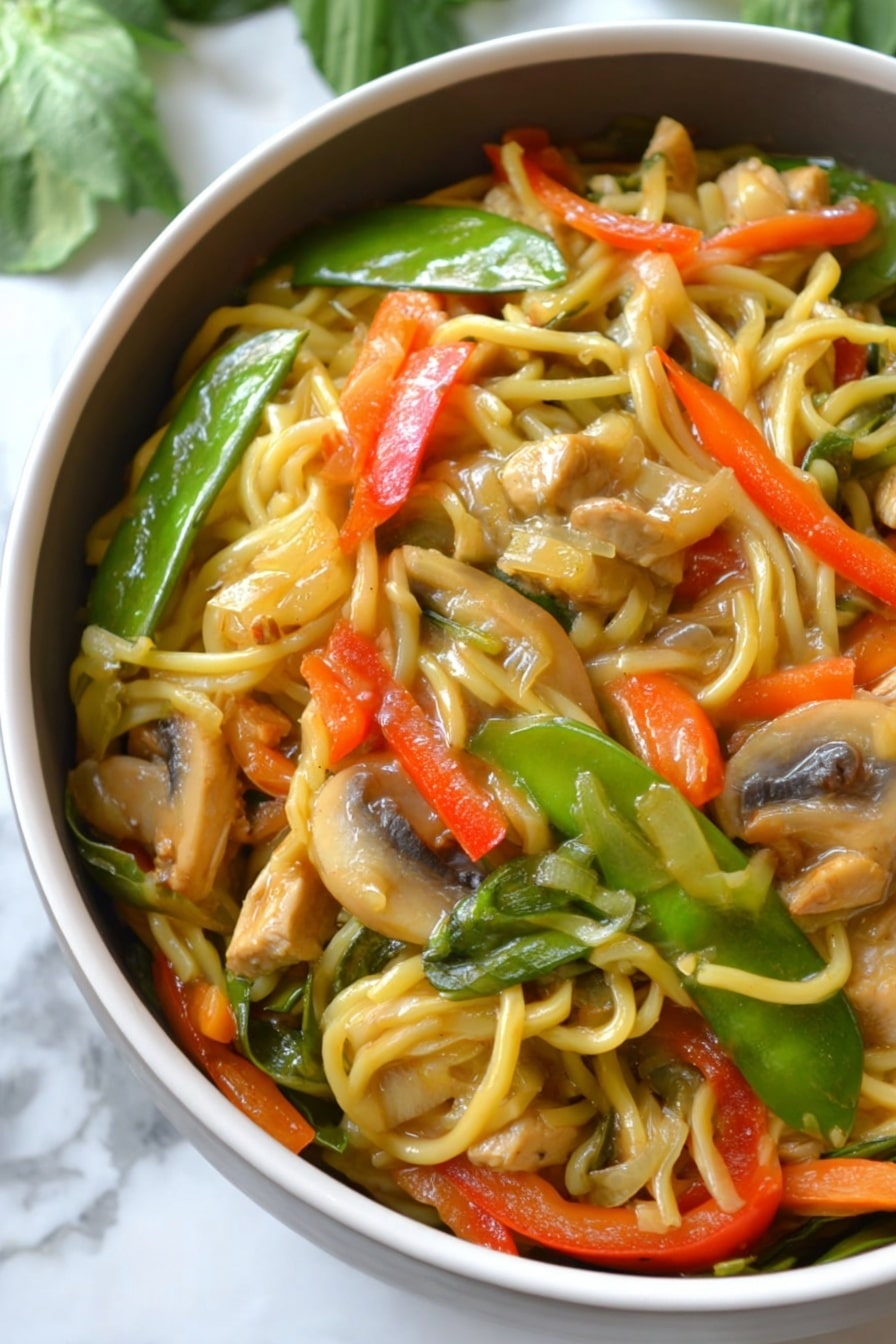 The image shows a close-up of a bowl filled with a colorful noodle stir-fry. The bottom layer consists of long, light yellow noodles, mixed evenly with sliced vegetables including bright green snow peas, orange thin carrot strips, chunky red bell pepper pieces, and light brown mushroom slices. There are also pieces of light tan tofu or chicken mixed into the dish. The noodles and vegetables are coated with a glossy sauce, giving them a shiny and slightly wet texture. The bowl is white, and it sits on a white marbled surface with some green leaves blurred in the background. photo taken with an iphone --ar 2:3 --v 7 - Instant Pot Chicken Lo Mein, easy chicken lo mein, quick Chinese stir-fry, healthy instant pot noodles, one-pot lo mein