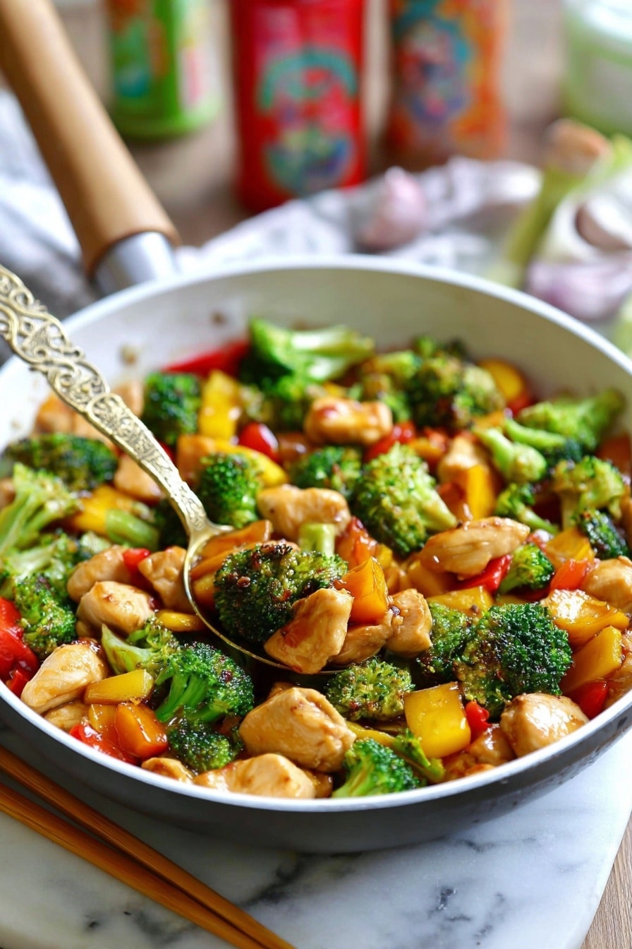 The image shows a white pan filled with a colorful stir-fry dish. The dish has three main layers: bright green broccoli florets with a fresh, bumpy texture, orange and yellow bell pepper pieces adding vibrant color and a slightly glossy texture, and light brown chicken pieces with a tender, soft look. A golden spoon with an intricate design rests in the middle of the pan, lifting some of the stir-fry. The whole scene is set on a white marbled surface, with a pair of wooden chopsticks lying beside the pan. In the background, some blurred colorful kitchen items add a cozy feel. Photo taken with an iphone --ar 2:3 --v 7 - Easy Chicken Stir Fry with Veggies, chicken stir fry recipes, quick healthy chicken dishes, flavorful stir fry dinner ideas, easy weeknight chicken recipes