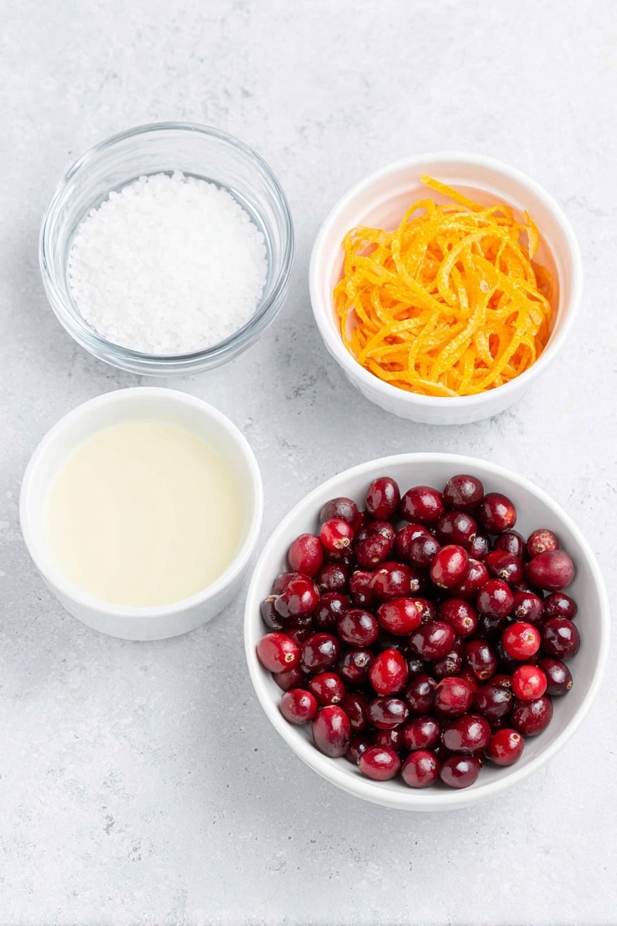 Flat lay of fresh, glossy red cranberries scattered alongside a small white ceramic bowl filled with granulated white sugar, a small white ceramic bowl containing bright, freshly squeezed orange juice, a simple white ceramic bowl with clear water, and a neat pile of vibrant orange zest strips, all arranged with perfect symmetry on a clean white marble surface, soft natural light, photo taken with an iPhone, professional food photography style, fresh ingredients, white ceramic bowls, no bottles, no duplicates, no utensils, no packaging --ar 2:3 --v 7 --p m7354615311229779997 - Homemade Cranberry Sauce with Orange, cranberry sauce recipe, orange cranberry sauce, easy cranberry sauce, holiday cranberry sauce