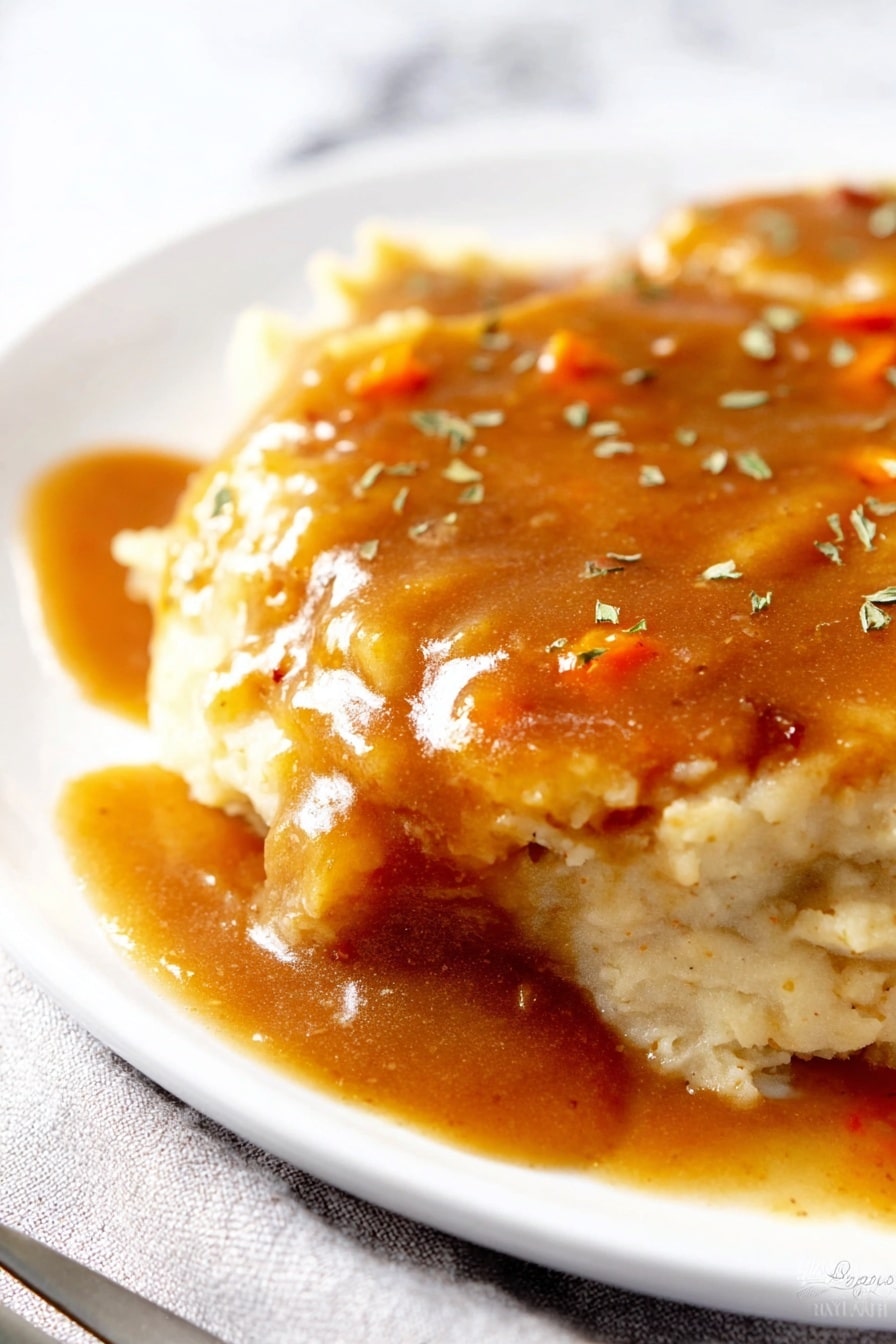 A close-up of a plate with two layers of light beige mashed potatoes, soft and creamy in texture. On top, there is a thick layer of brown gravy with a shiny, smooth texture, containing small orange bits, possibly carrots. The gravy is spread evenly, slightly dripping on the sides. The dish is sprinkled with small green herb pieces. The white plate rests on a white marbled surface with a silver fork partially visible on the bottom left side. Photo taken with an iphone --ar 2:3 --v 7 - Creamy Cabbage Coleslaw, cabbage coleslaw side dish, easy coleslaw recipe, healthy coleslaw salad, flavorful cabbage slaw