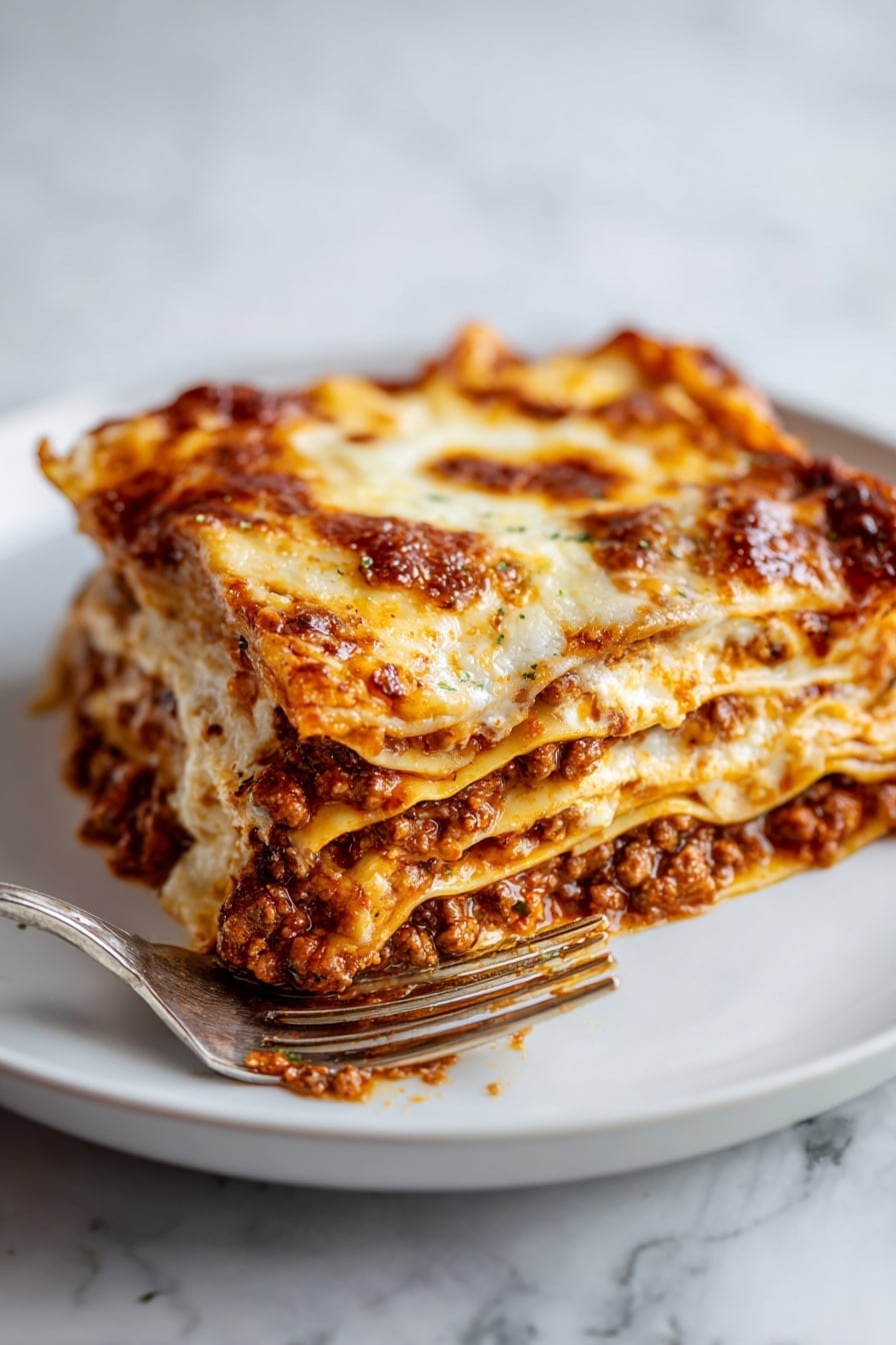 A close-up view of a slice of lasagna on a white plate, showing four layers of pasta sheets with rich brown meat sauce and melted cheese in between. The top layer is golden brown and bubbly with some darker spots. A fork is holding the front corner of the slice, and a knife is lifting the back edge slightly. The background and surface have a white marbled texture. photo taken with an iphone --ar 2:3 --v 7 - Authentic Lasagne Bolognese, homemade lasagne layers, traditional Italian lasagne, slow-cooked meat sauce, creamy béchamel lasagne