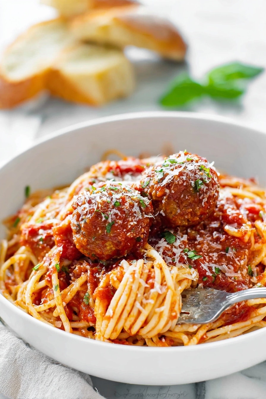 A large red pot holds a mix of spaghetti and meatballs in a rich tomato sauce. The spaghetti is long and golden, twisted around and soaked in the chunky red sauce. The meatballs are round and brown, scattered evenly through the noodles, some partially covered with sauce. A wooden spoon with a smooth light wood texture is stirring the pasta, with some sauce on it. The pot’s inside edge shows a coating of the thick tomato sauce. The background has a white marbled texture. photo taken with an iphone --ar 2:3 --v 7 - Homemade Spaghetti and Meatballs, Italian comfort food, homemade marinara, easy pasta recipes, classic meatball recipe