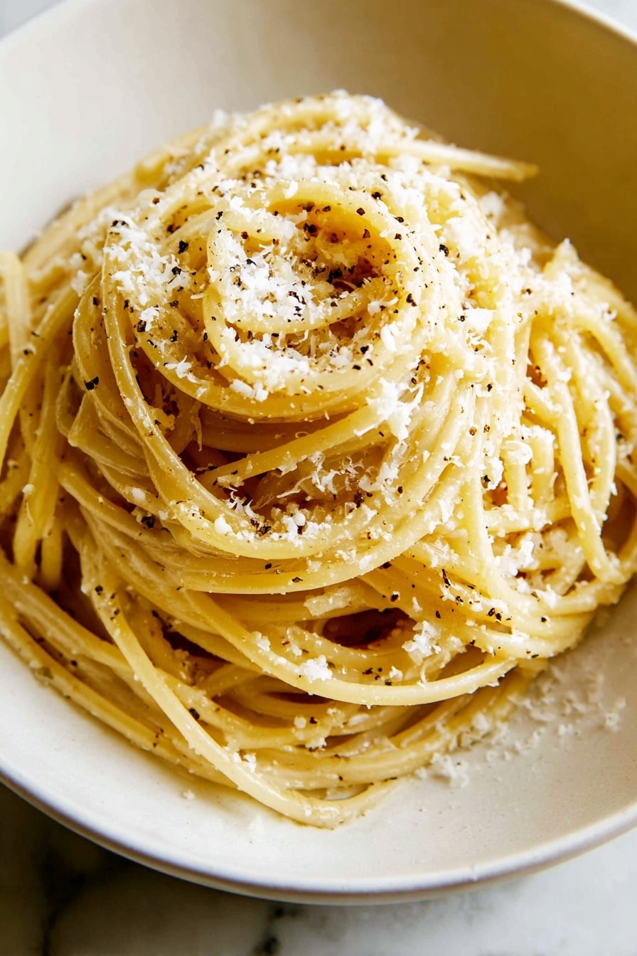 A white bowl holds a mound of spaghetti pasta coated in a light yellow sauce, speckled with small black pepper bits, with finely grated white cheese sprinkled over the top layer. A fork lifts a bundle of the pasta above the bowl, showing the smooth texture and twist of the noodles. In the background, there is a small white bowl with more grated cheese. The scene is set on a white marbled surface. photo taken with an iphone --ar 2:3 --v 7 - Cacio e Pepe Pasta, Italian pasta recipes, easy pasta dishes, quick weeknight dinners, creamy cheese pasta