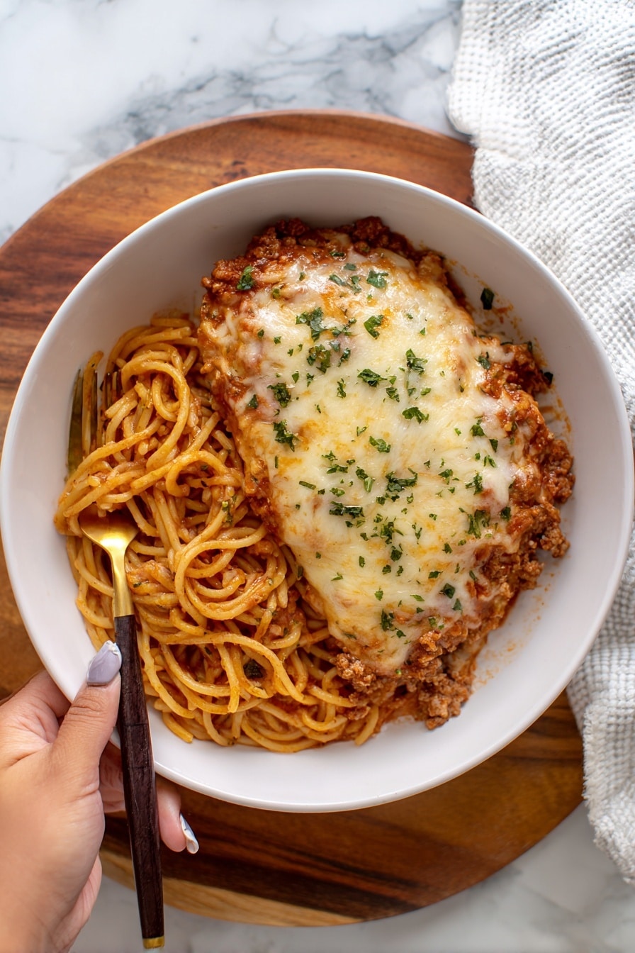 A white rectangular baking dish filled with a layered lasagna, showing golden-brown melted cheese on top with some darker browned spots and red tomato sauce peeking through. The edges are bubbly and slightly crispy, showing a textured mix of cheese and sauce. Around the dish, there is a beige cloth beneath, and on the white marbled surface near the top-left corner, there are two small white bowls, one filled with fresh green parsley and the other with thin white slices, possibly cheese. photo taken with an iphone --ar 2:3 --v 7 - Baked Spaghetti with Sausage and Cheese, cheesy baked spaghetti recipe, hearty sausage pasta bake, easy comfort food recipe, family-friendly baked pasta