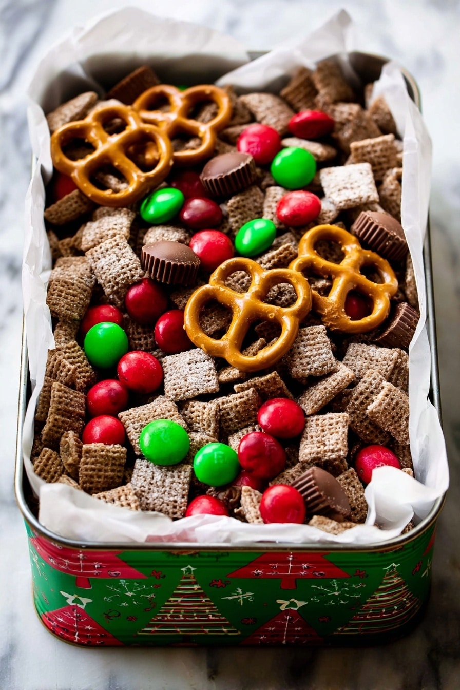 A rectangular tin with Christmas tree designs on the sides holds a festive snack mix. The mix contains many layers of square, brown, sugar-coated cereal pieces forming the base layer. Scattered on top are bright red and green candy-coated chocolates, some round and some smaller. Large golden-brown pretzels are placed unevenly across the top layer, along with several small, smooth milk chocolate peanut butter cups. The tin is lined with white parchment paper that spills over the edges slightly, all set on a white marbled surface. photo taken with an iphone --ar 2:3 --v 7 - Christmas Reindeer Chow, Christmas Reindeer Chow recipe, holiday snack mix, festive chocolate peanut butter snack, easy Christmas treats