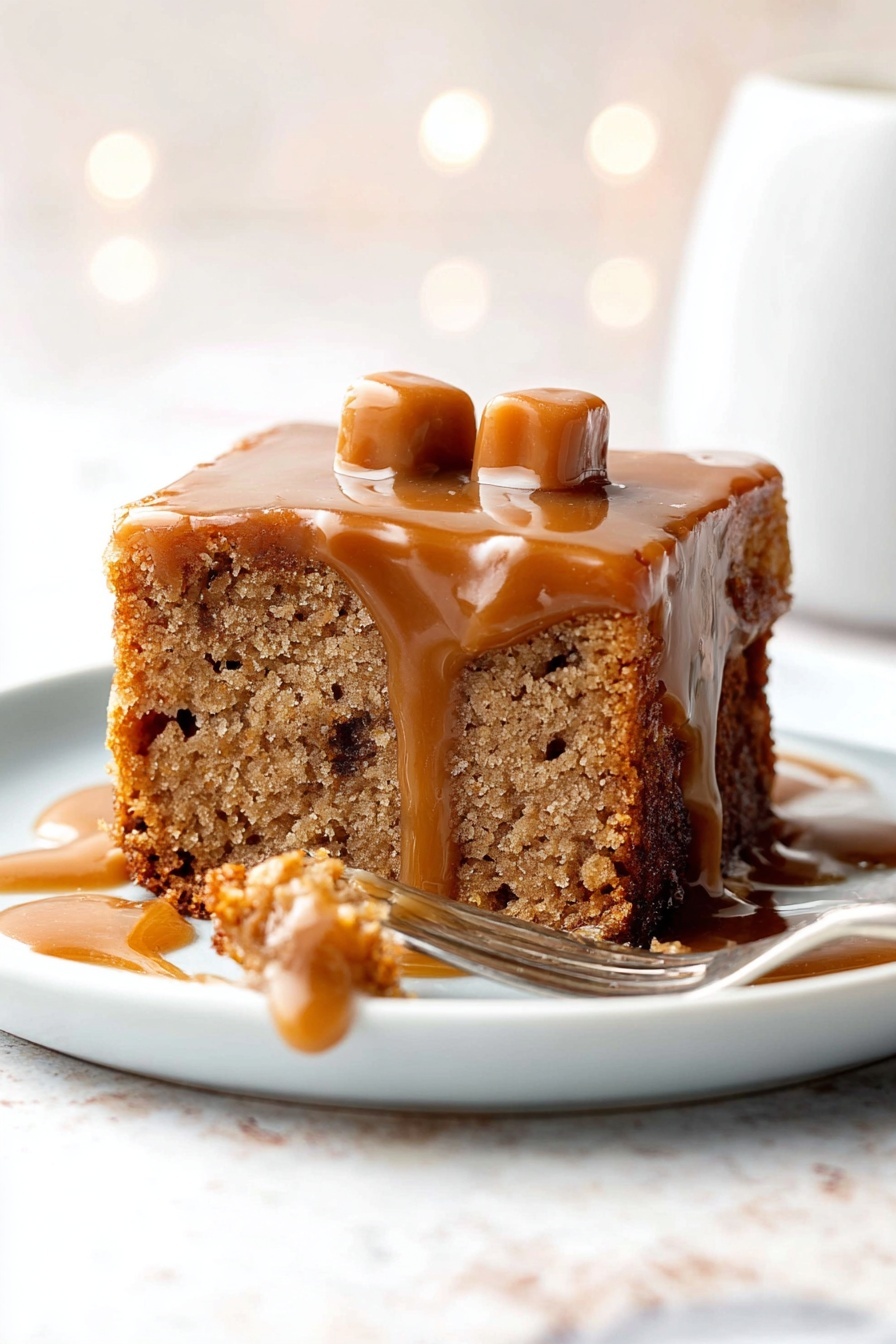 The image shows a square piece of light brown cake with visible texture and small darker spots inside, placed on a white plate. The cake has a layer of shiny caramel sauce dripping down its sides, slightly pooling on the plate. On top of the cake, there are two small, light tan caramel candies. A fork lies on the right side of the plate, with a small bite of the cake covered with caramel sauce resting near it. The background has a white marbled texture and soft bokeh light effects. Photo taken with an iphone --ar 2:3 --v 7 - Sticky Toffee Pudding with Toffee Sauce, luscious toffee pudding recipe, moist sticky date dessert, easy toffee pudding with sauce, comforting dessert recipes