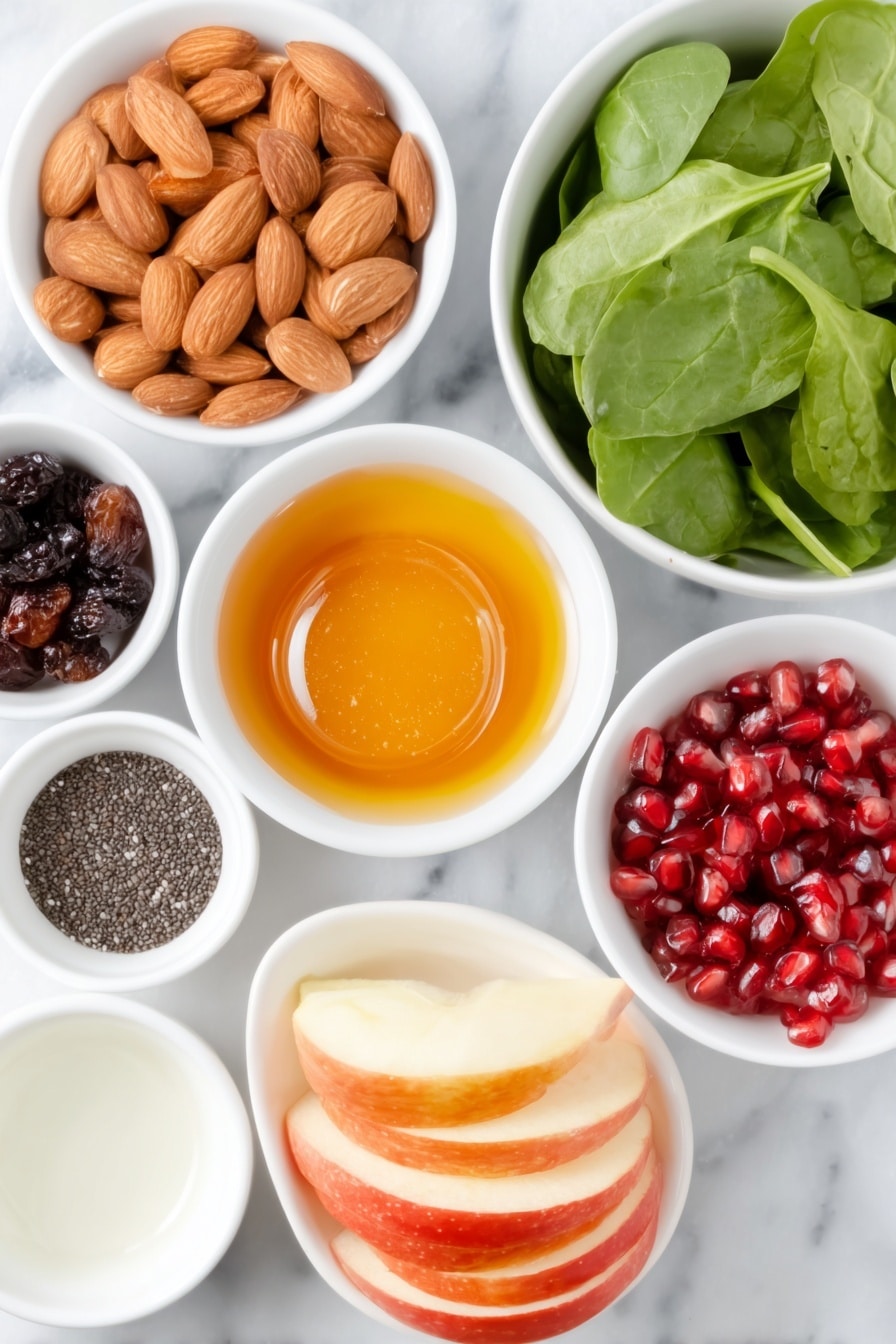Flat lay of slivered almonds, small white bowl of extra virgin olive oil, small white bowl of honey, small white bowl of kosher salt, small white bowl of dried cranberries, small white bowl of water, small white bowl of apple cider vinegar, medium clove of garlic, small white bowl of freshly ground black pepper, small white bowl of poppy seeds, large bunch of fresh baby spinach leaves, large crisp red apple thinly sliced, small white bowl of bright red pomegranate arils, whole uncracked brown eggs absent (none in recipe) placed on a clean white marble surface, soft natural light, photo taken with an iPhone, professional food photography style, fresh ingredients, white ceramic bowls, no bottles, no duplicates, no utensils, no packaging --ar 2:3 --v 7 --p m7354615311229779997 - Apple Cranberry Spinach Salad, healthy fruit and vegetable salad, festive holiday salad, easy seasonal salad, fresh spinach and berry salad