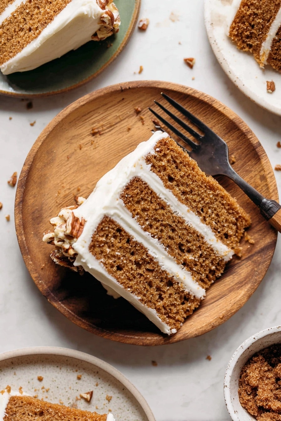 A slice of three-layer light brown cake with white cream frosting between each layer and around the edges sits on a round white plate with wood texture. The cake texture looks soft with small holes inside. There is a dark fork placed on the plate, partly holding the cake slice. Some small brown nut pieces are scattered on the white marbled surface under and around the plate. Part of another white plate with a similar cake slice is visible in the top right corner, while at the bottom right, there is a white bowl with a brown crumbly topping inside. Photo taken with an iphone --ar 2:3 --v 7 - Spice Cake with Brown Butter Cream Cheese Frosting, fall spice cake recipe, moist spice cake with cream cheese frosting, warm holiday spice cake, cozy layered spice cake