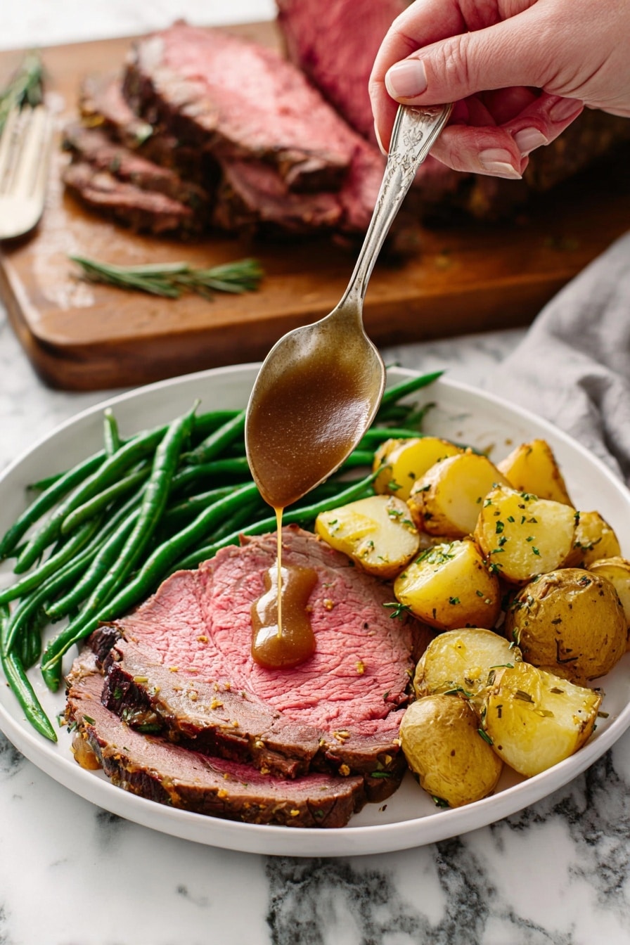 A white plate holds a meal with three layers: a large slice of pink roast beef with a browned edge forms the base layer, topped with bright green cooked green beans arranged in a neat pile along one side, and golden roasted potato chunks with herbs sit next to the green beans. A woman's hand holds a silver spoon above the beef, pouring rich brown gravy directly onto the meat. In the background, a wooden board with a large piece of roast beef resting on it is visible against a white marbled surface. Photo taken with an iphone --ar 2:3 --v 7 - Garlic Herb Prime Rib, prime rib roast, garlic herb roast, holiday prime rib, juicy prime rib