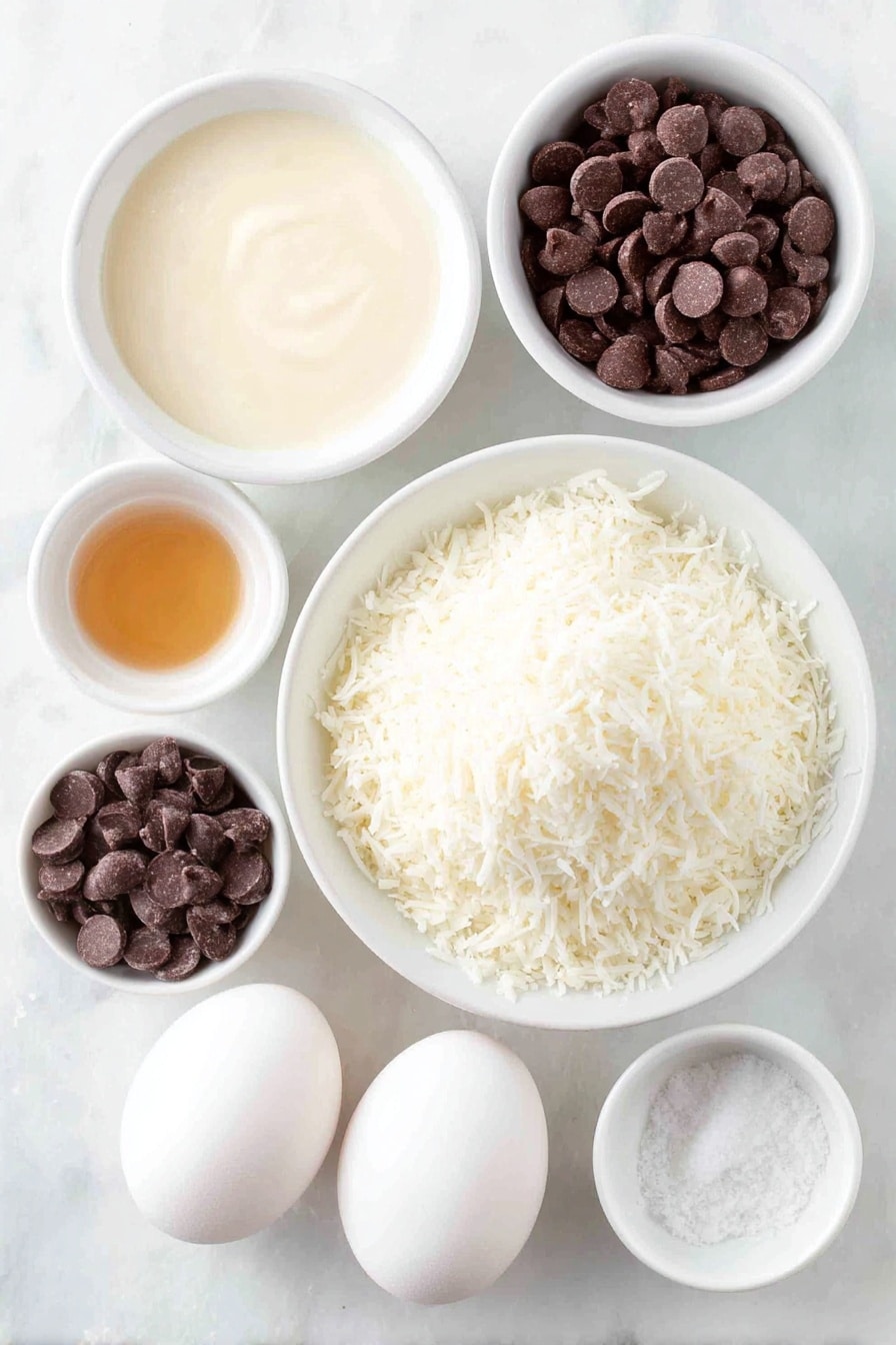 Flat lay of a small mound of fresh sweetened shredded coconut, a small white bowl filled with thick sweetened condensed milk, a few drops of golden vanilla extract in a tiny white bowl, a pinch of coarse salt in another small white bowl, two large whole white eggs with clean shells, and a small white bowl of glossy semi-sweet chocolate chips, all arranged in perfect symmetry on a clean white marble surface, soft natural light, photo taken with an iPhone, professional food photography style, fresh ingredients, white ceramic bowls, no bottles, no duplicates, no utensils, no packaging --ar 2:3 --v 7 --p m7354615311229779997 - Chocolate Dipped Coconut Macaroons, Coconut Macaroons with Chocolate, Chewy Coconut Cookies, Easy Coconut Dessert, Homemade Chocolate Cookies